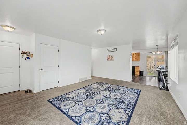 Carpeted living area with white walls and ceiling-mounted dome lighting