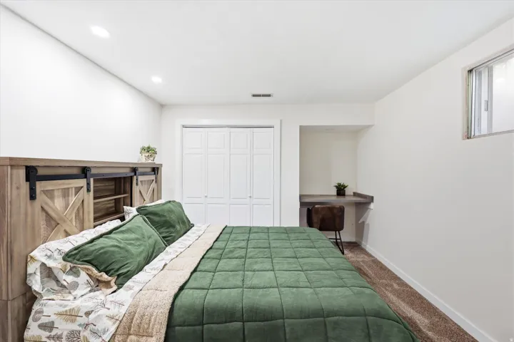 Bedroom featuring a built-in desk, recessed lighting, and carpet flooring