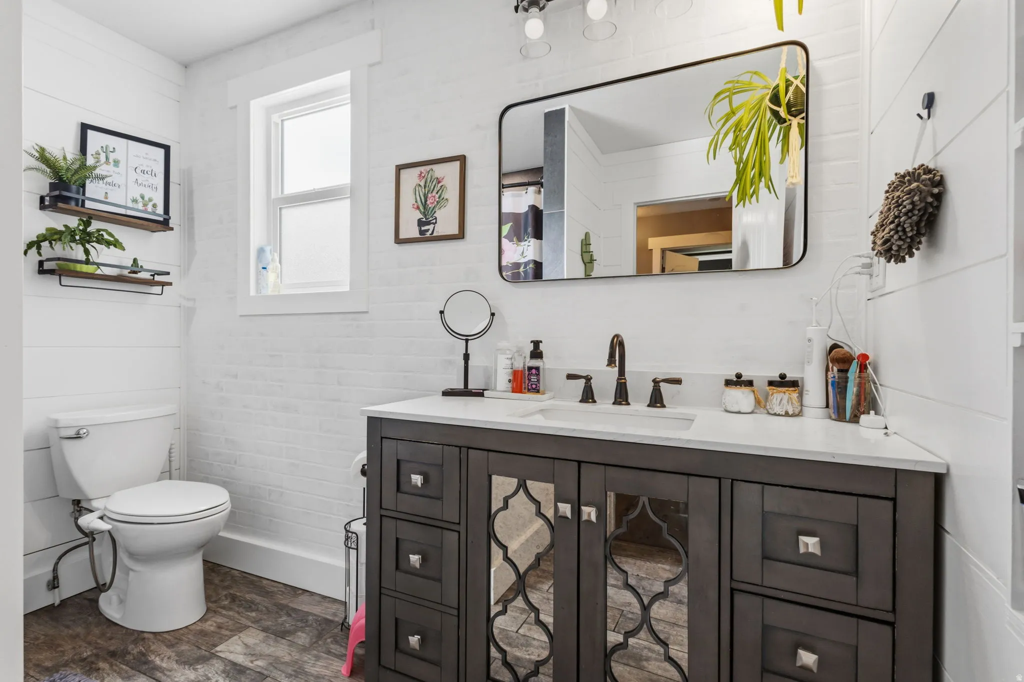 Bathroom featuring a dark wood-finish vanity with a light countertop, an undermount sink, and a dark bronze-finish faucet