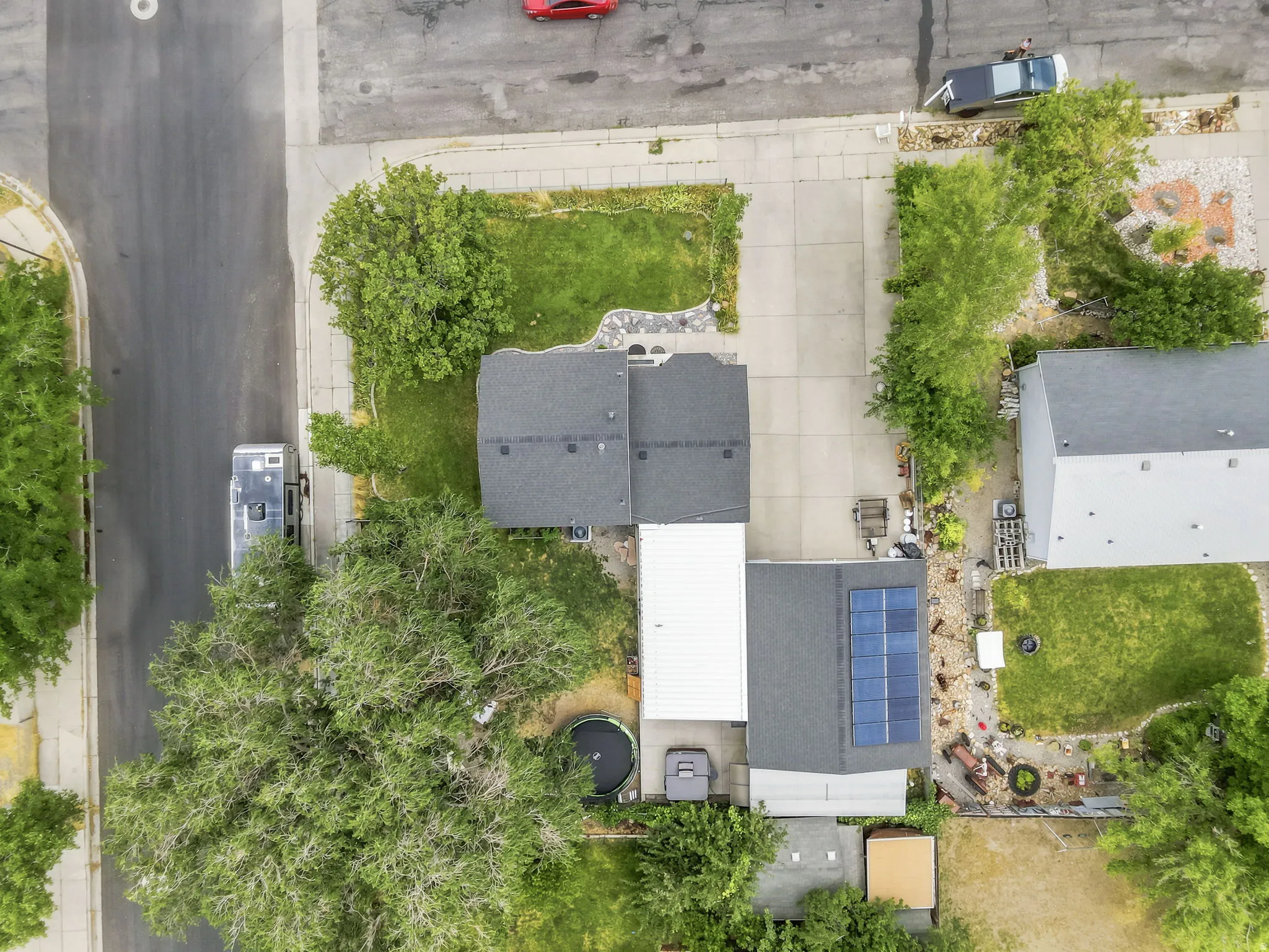 Property featuring a dark shingle roof, solar panels, and a concrete driveway