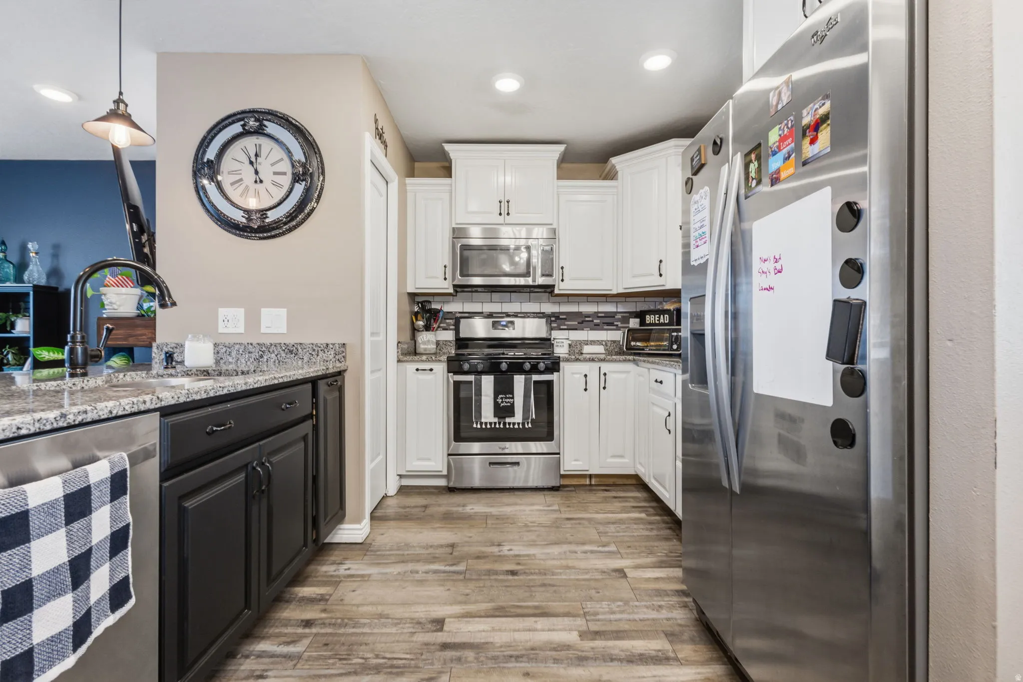 Kitchen featuring wood-finish flooring and a two-tone cabinetry scheme