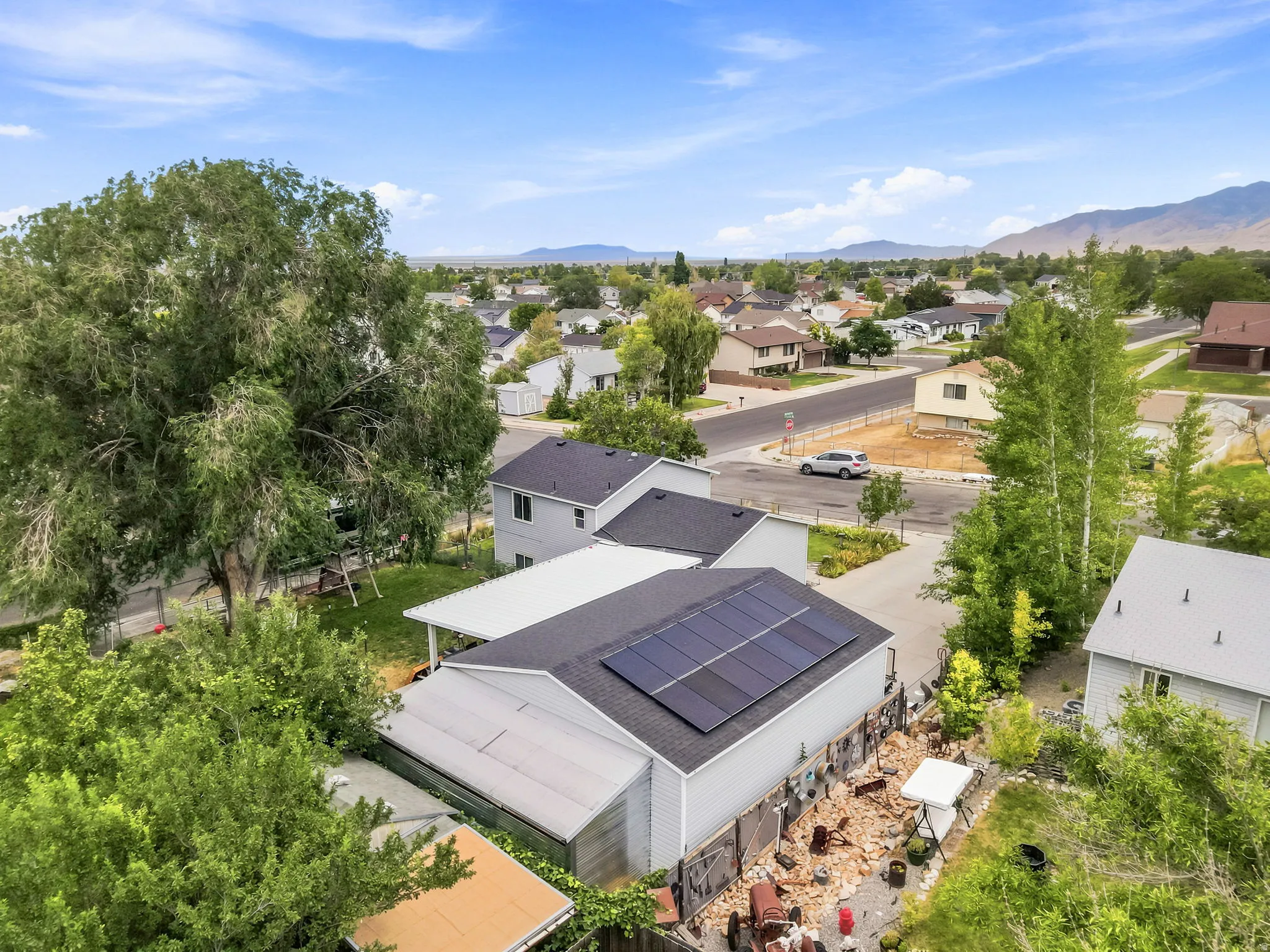 Contemporary residence featuring rooftop solar panels and a detached carport
