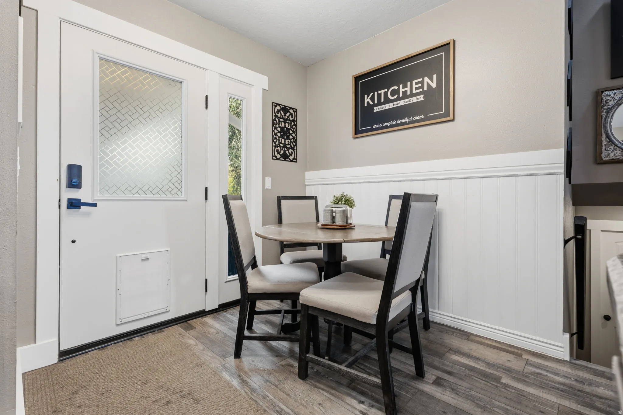 Entry area featuring wood-finish flooring and a white paneled door with decorative glass