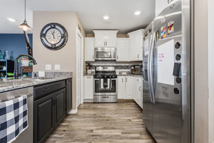Kitchen featuring wood-finish flooring and a two-tone cabinetry scheme