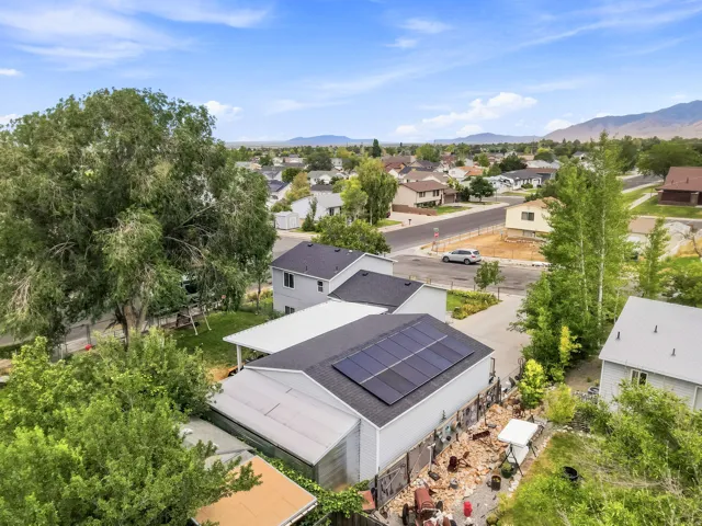 Contemporary residence featuring rooftop solar panels and a detached carport