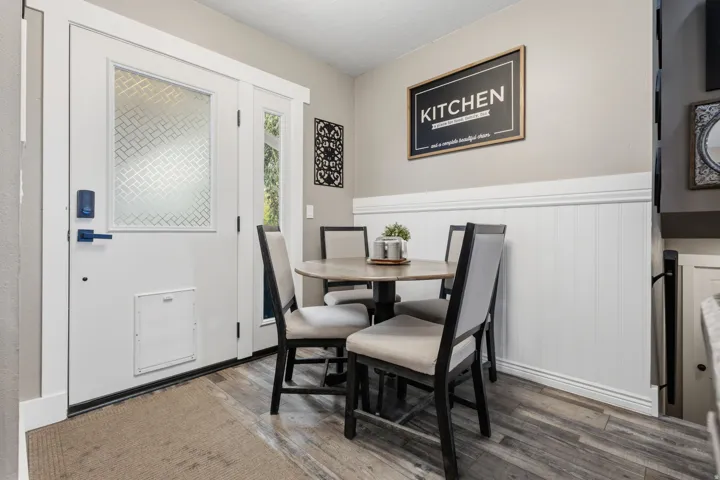Entry area featuring wood-finish flooring and a white paneled door with decorative glass