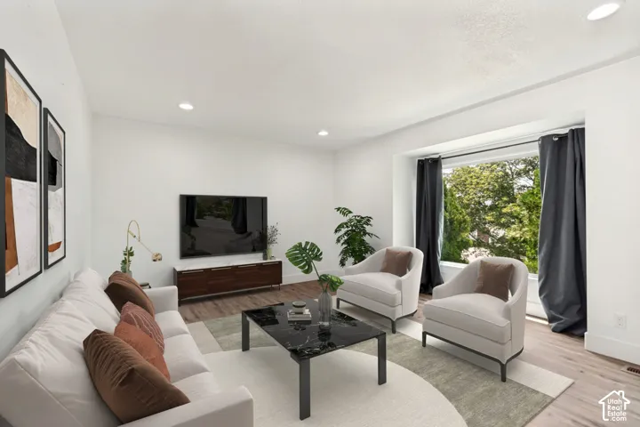 Living area featuring wood-finish flooring, recessed lighting, and a prominent bay window