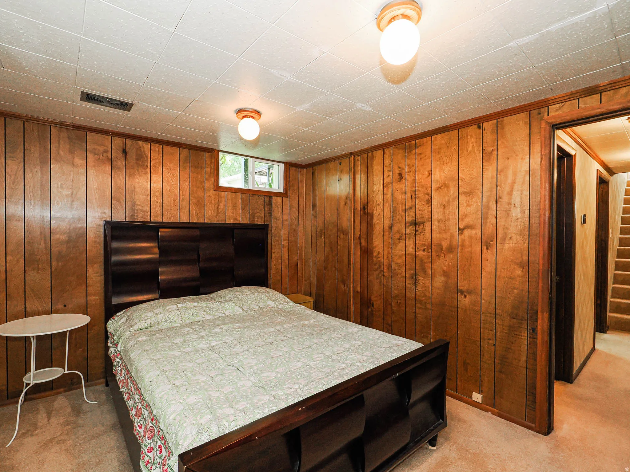 Paneled wall detailing with wood-finish trim, recessed window, carpeted flooring, and ceiling-mounted lighting