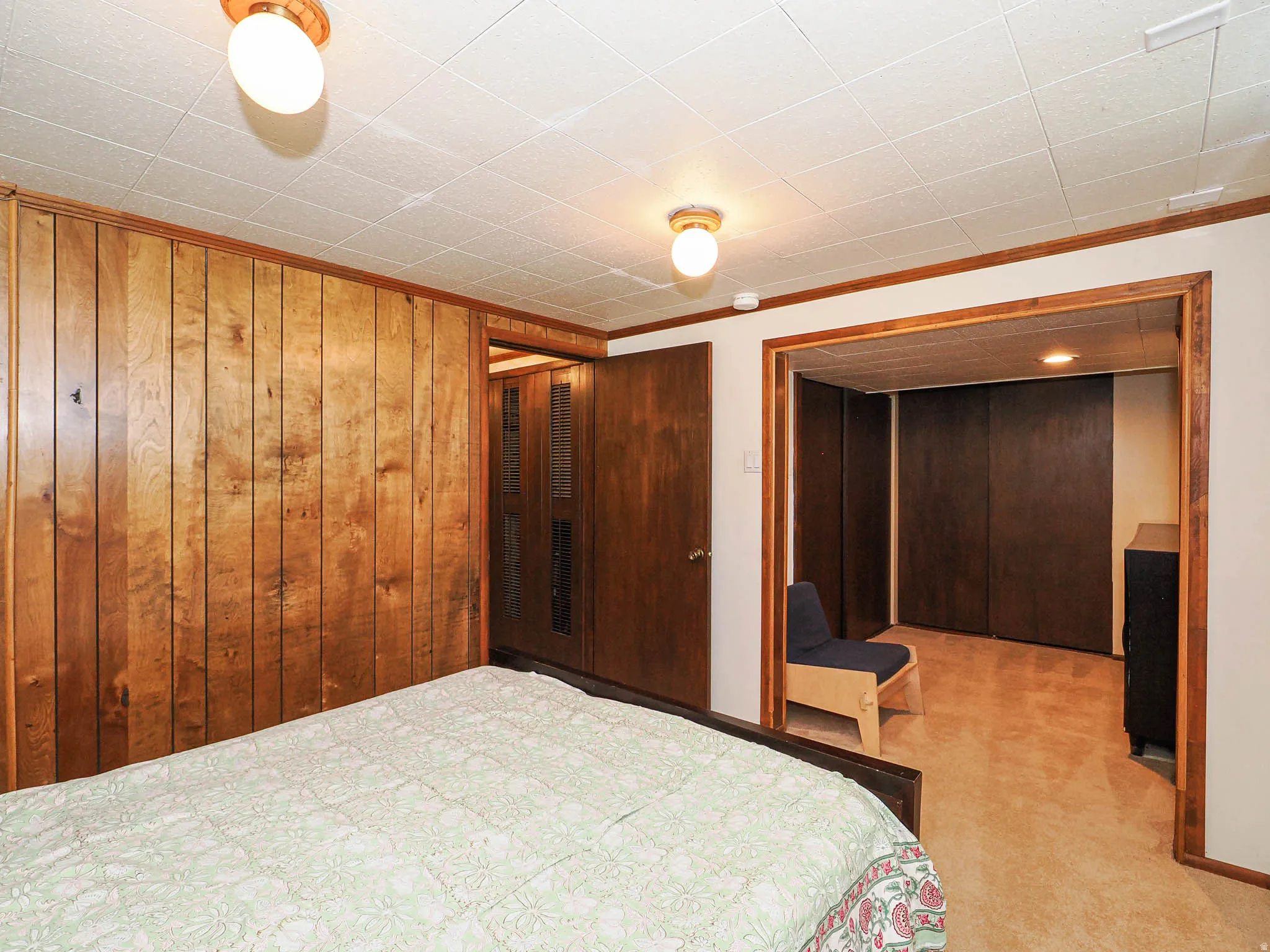 Wood-paneled wall and built-in closet with sliding doors