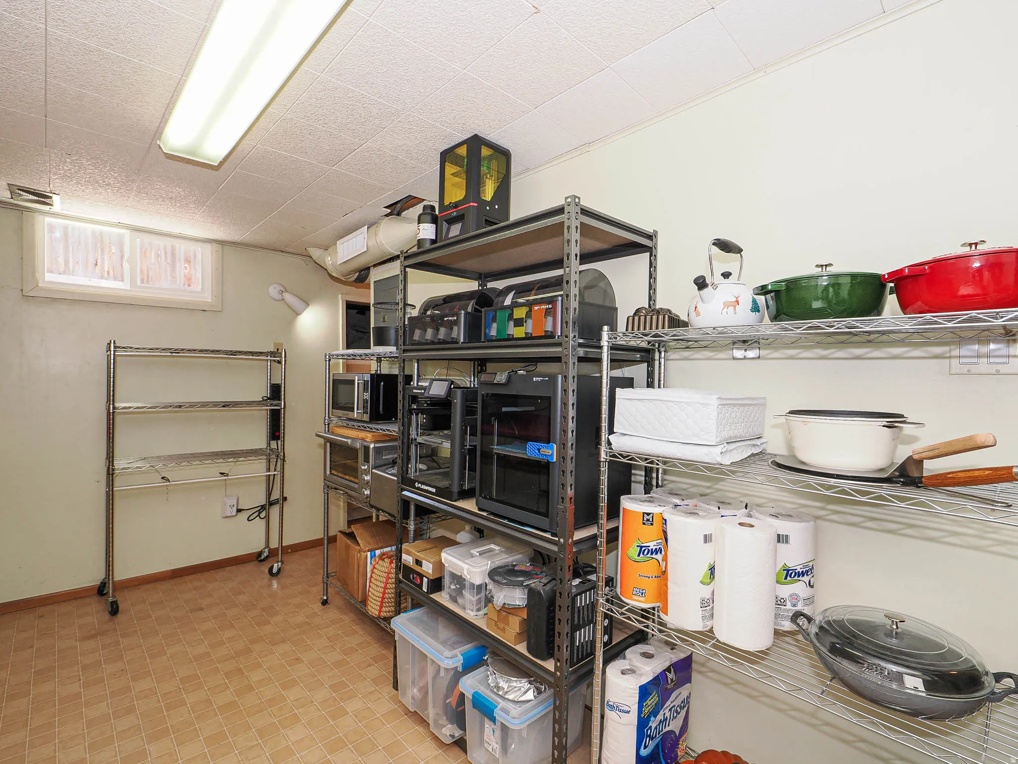 Utility room featuring a drop ceiling, a single window, and neutral wall paint