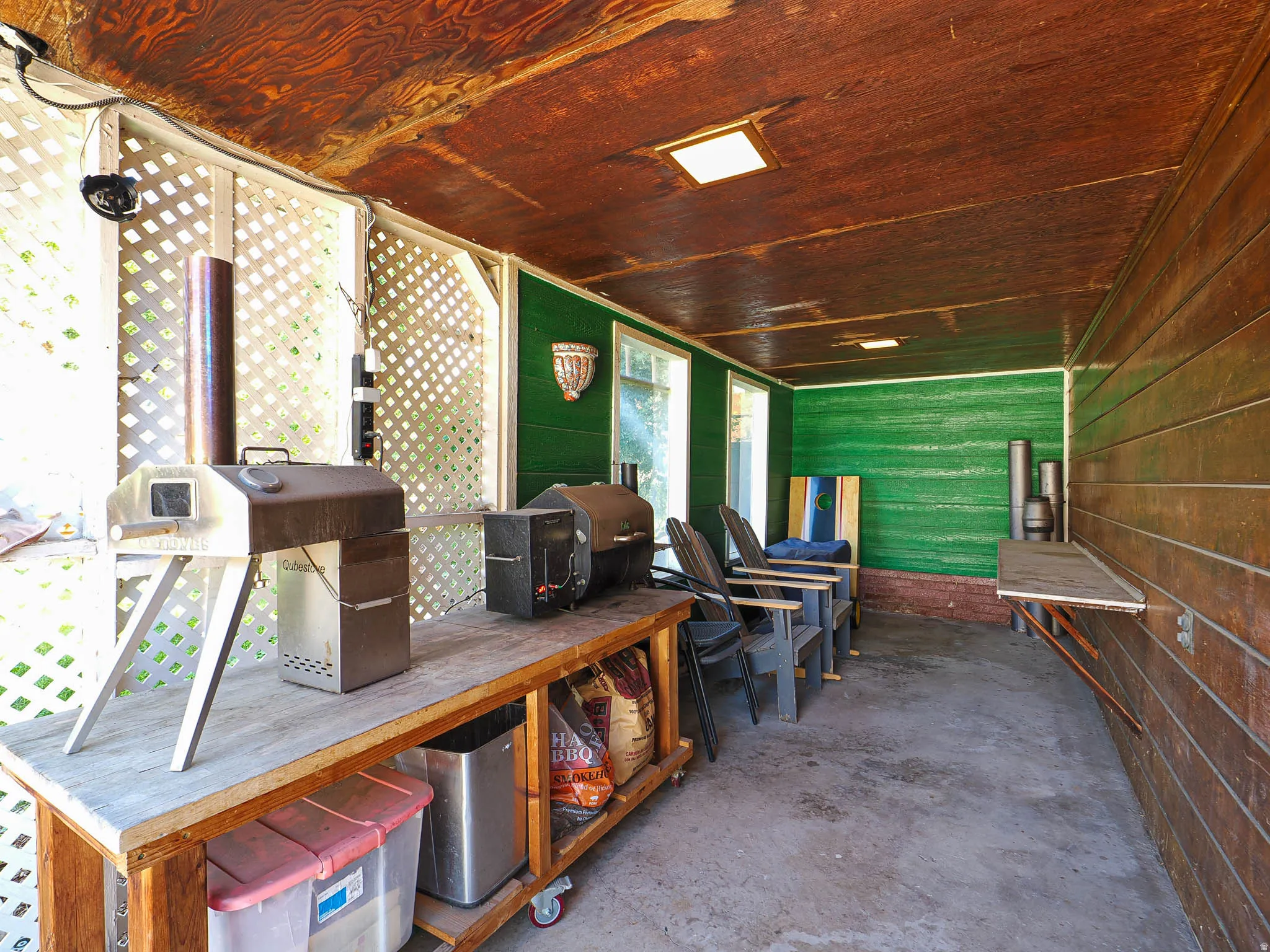 Covered patio featuring a wood-finish ceiling, concrete flooring, and lattice screening