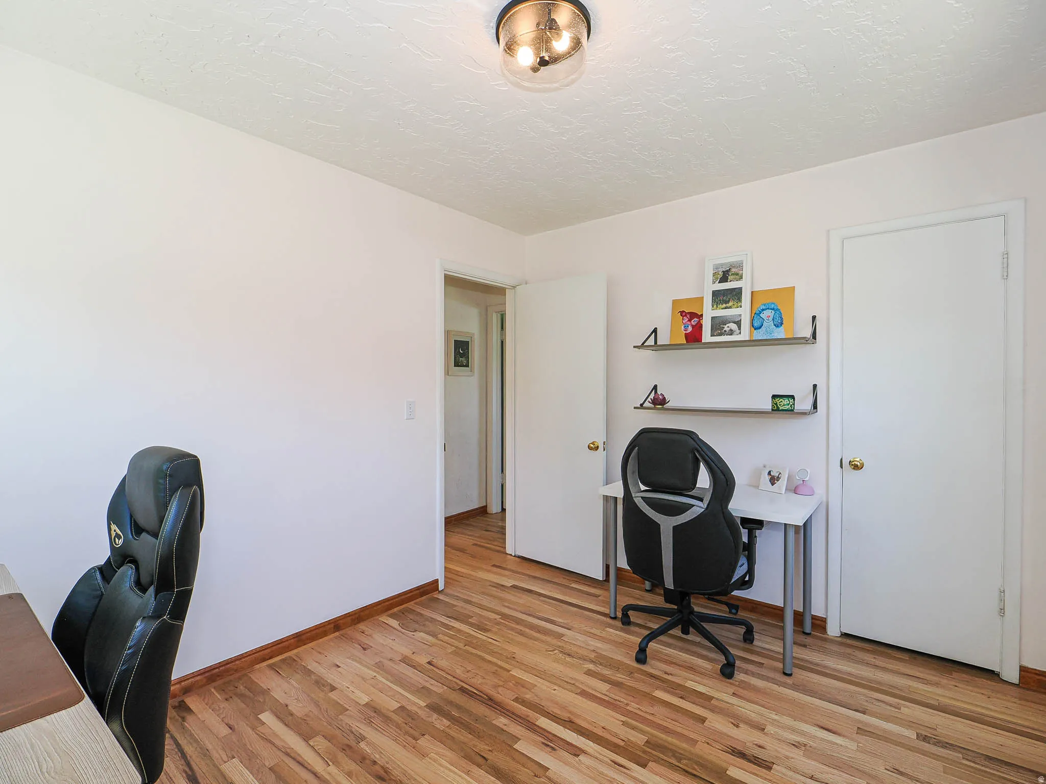Room featuring wood-finish flooring, white walls, and a semi-flush mount ceiling light fixture