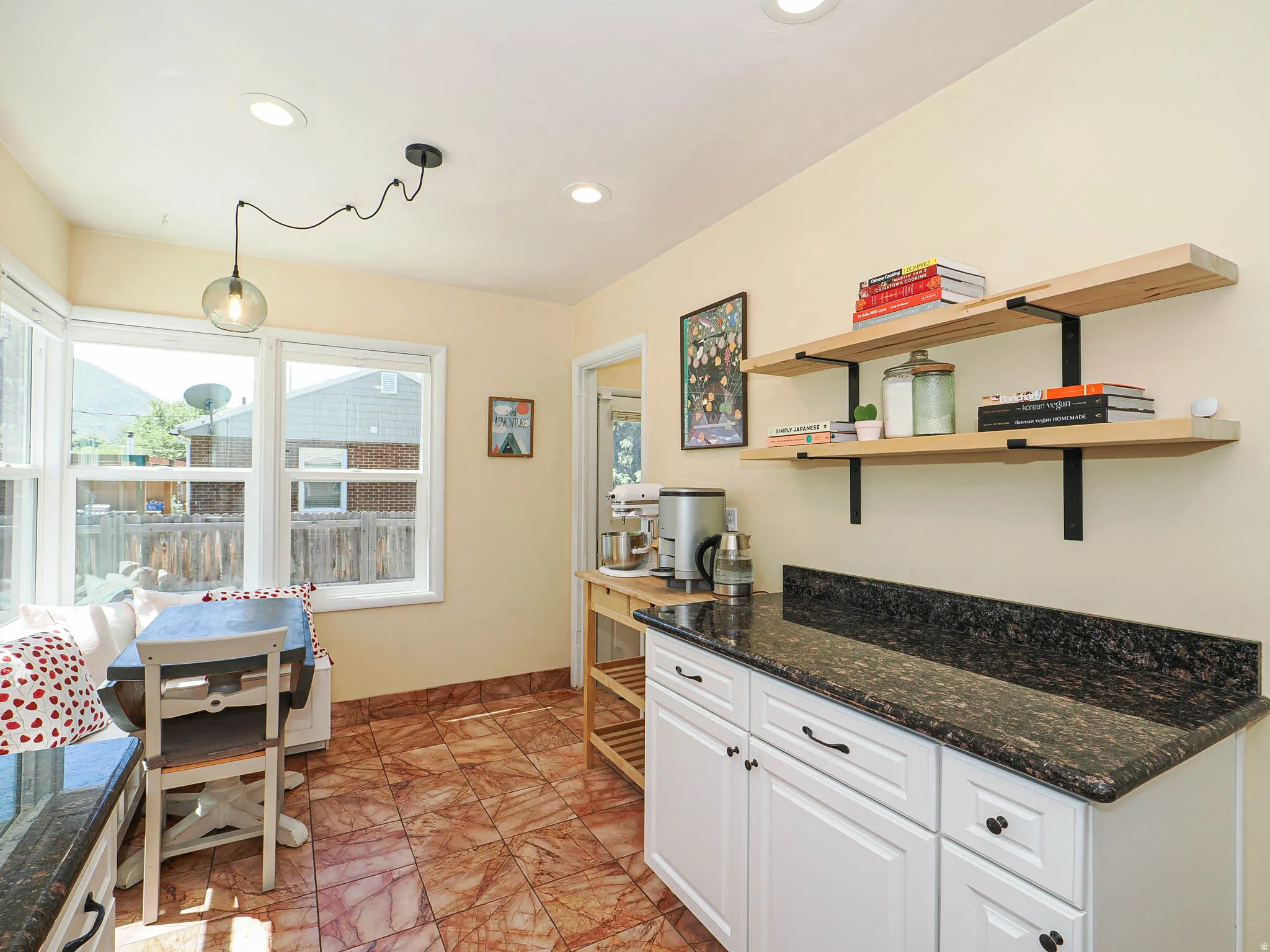Bright kitchen nook featuring natural light, recessed lighting, and a modern pendant light