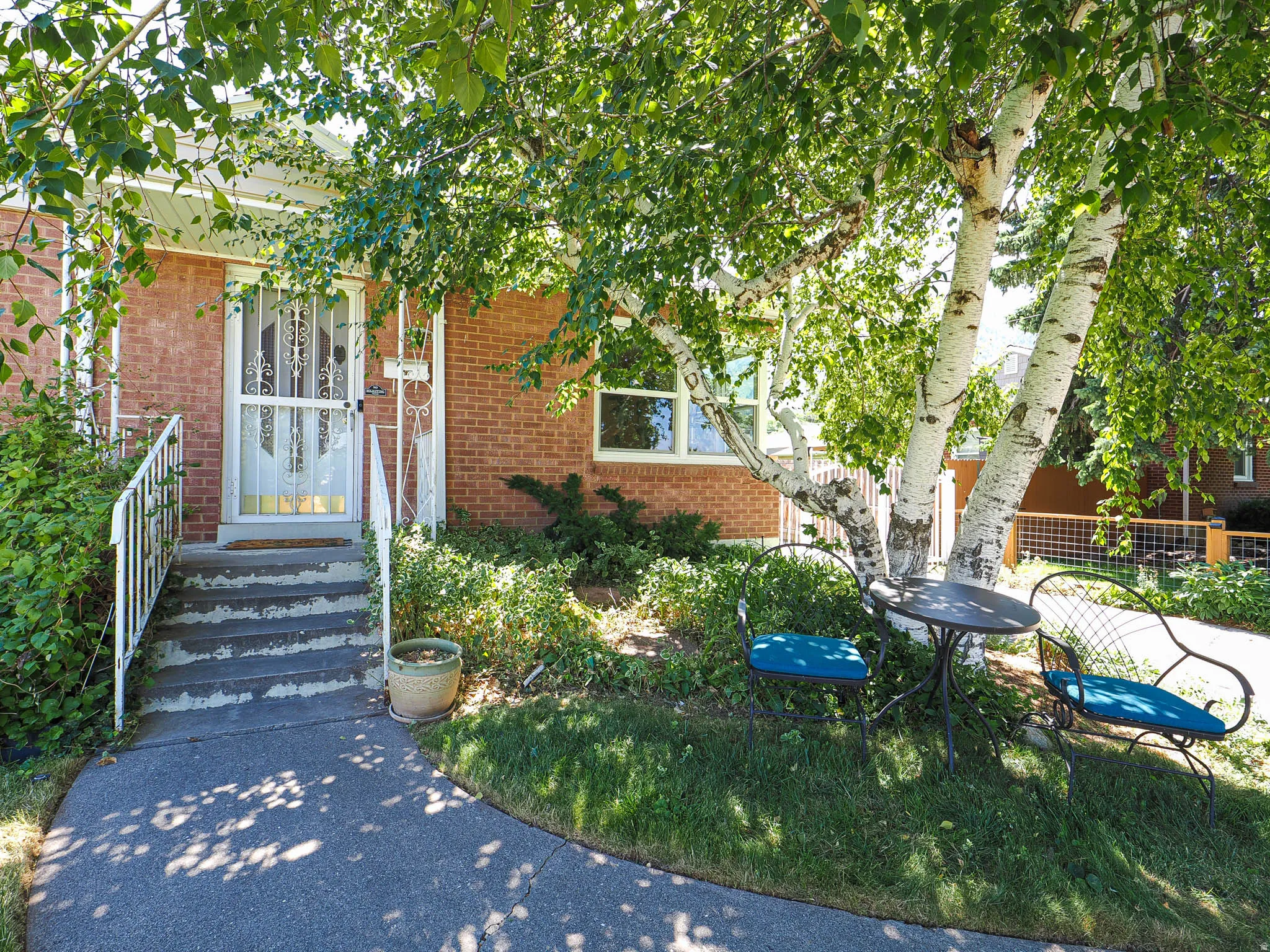 Brick facade featuring a covered entry with white railings