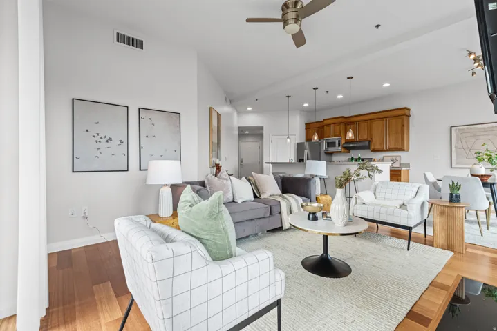 Open-concept living area featuring high ceilings, wood-finish flooring, and a ceiling fan