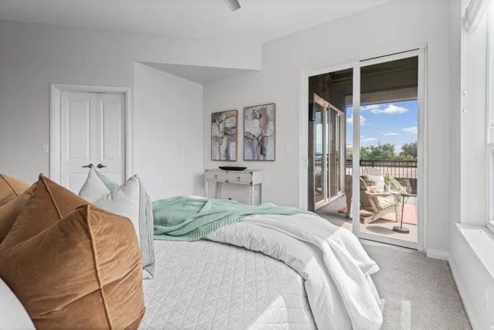 Bedroom with light gray carpeting and a double-door closet
