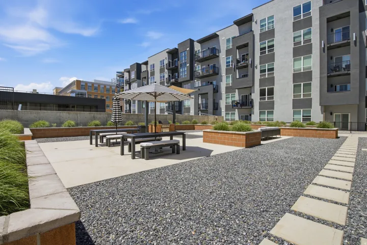 Spacious outdoor patio area featuring a concrete slab, dark gravel, and raised brick planters