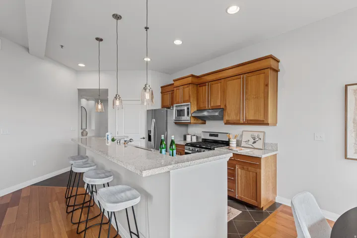 Kitchen featuring light wood cabinetry, stainless steel appliances, and a gas range