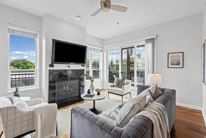 Living area featuring a black stone fireplace with a mantel, recessed lighting, and a ceiling fan