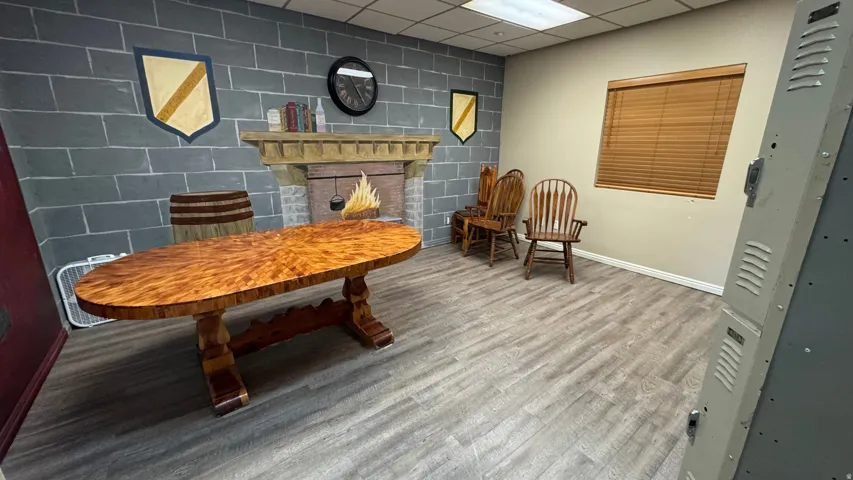 Spacious room featuring wood-finish flooring, a wall with block-pattern painting, and an integrated decorative fireplace