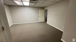 Spacious commercial room featuring neutral-toned carpeting, light gray painted walls, and white trim molding