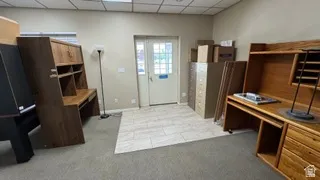Room with carpeted flooring and a light-toned tiled entrance