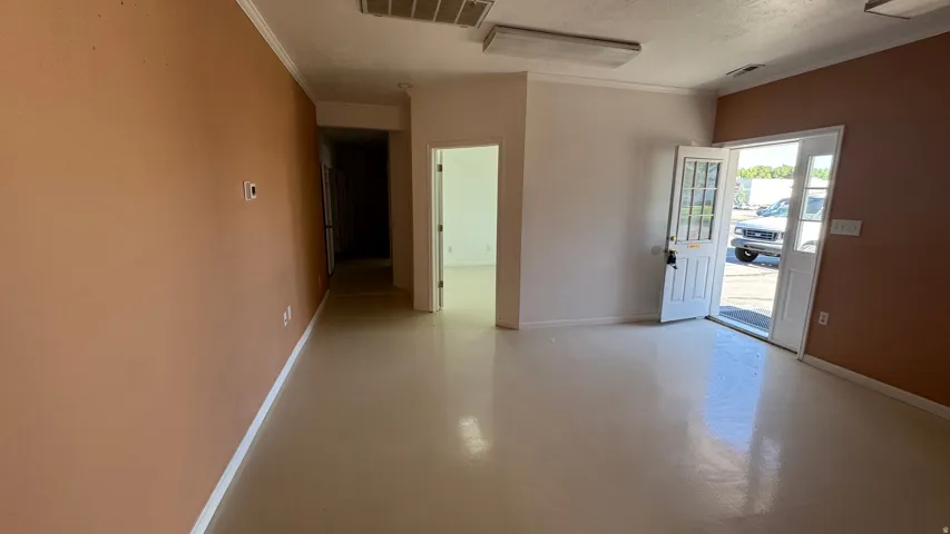 Entry area featuring a solid door with transom window, recessed fluorescent lighting, light-toned flooring, and painted walls
