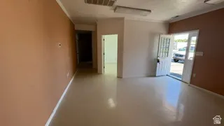 Spacious open-concept room featuring light-toned flooring, two-tone painted walls, and crown molding