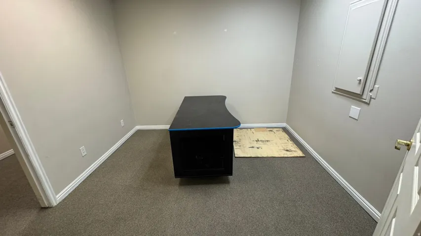 Carpeted room with neutral wall paint and white baseboards