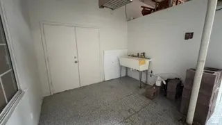Utility room featuring a double-door entry, a utility sink, and a concrete floor