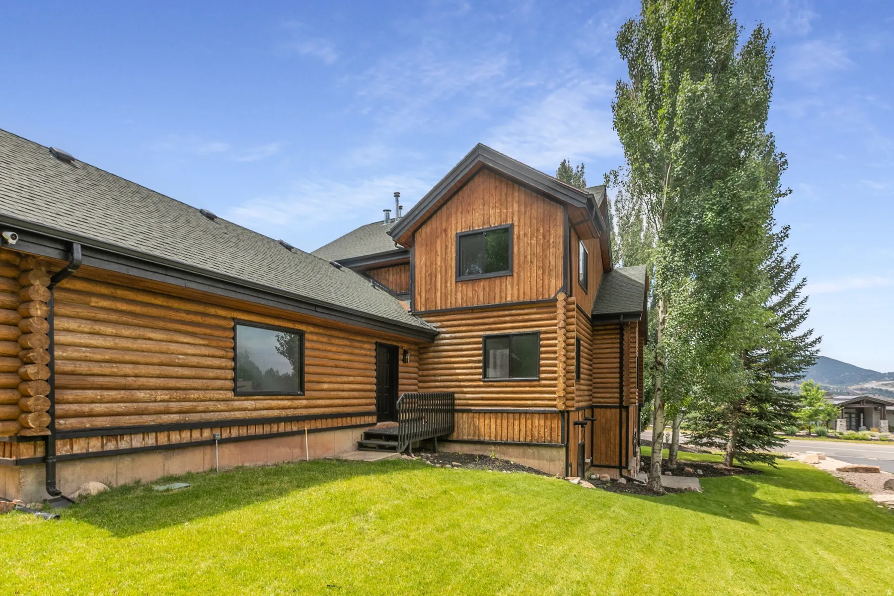 Log cabin-style exterior with dark trim and black framed windows