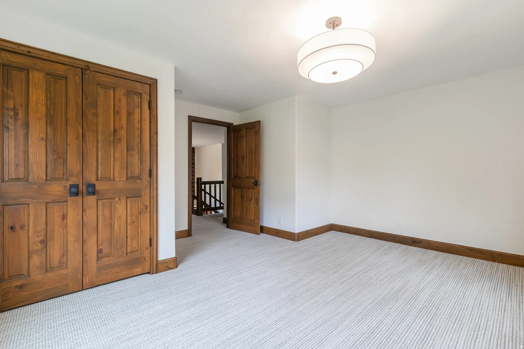 Neutral-toned wall-to-wall carpeting and white walls