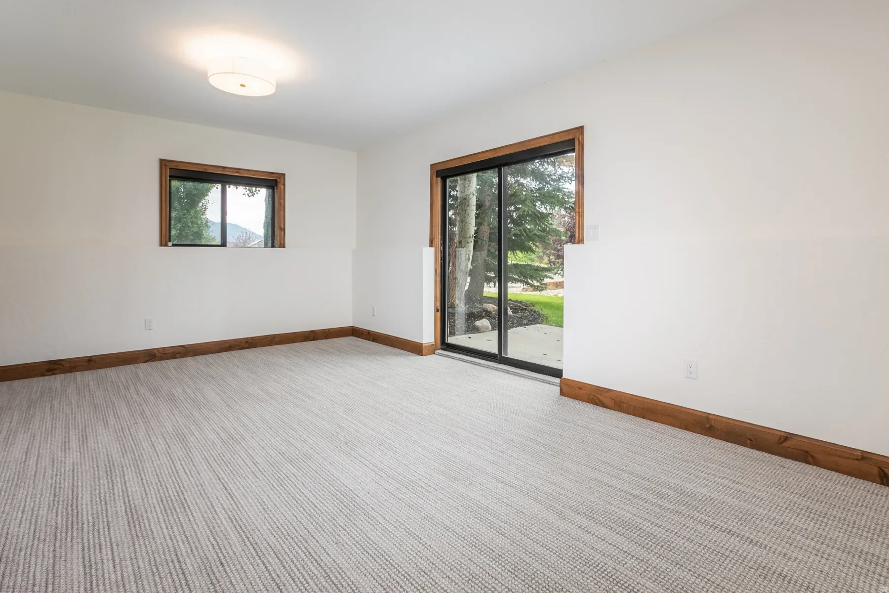 Spacious room featuring light-toned striped carpeting and white walls