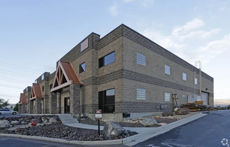 Commercial building with a stone-accented facade, multiple entryways featuring copper-toned awnings, and block construction