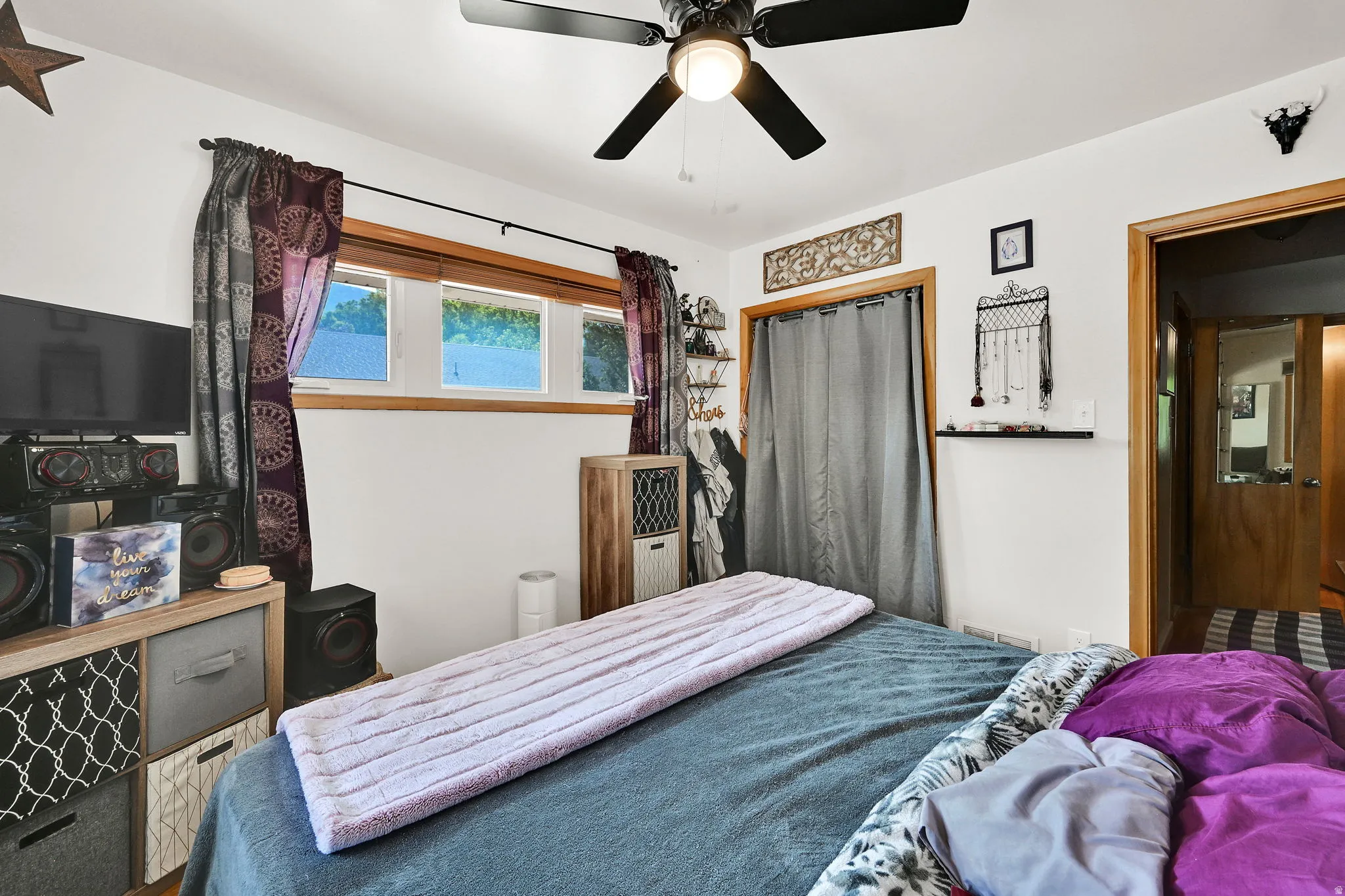 White walls with natural wood trim, multi-pane windows, and a ceiling fan with integrated lighting