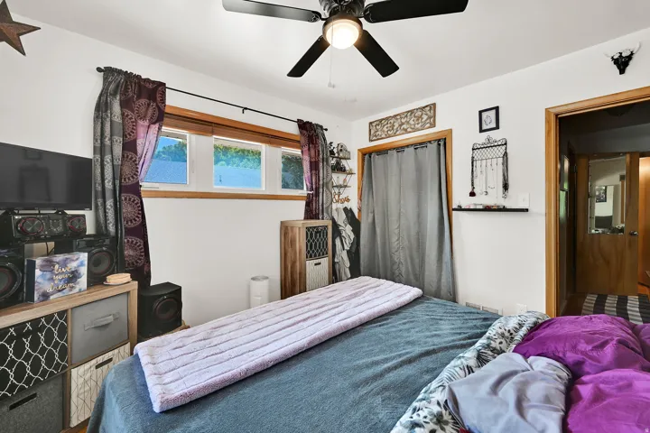 White walls with natural wood trim, multi-pane windows, and a ceiling fan with integrated lighting