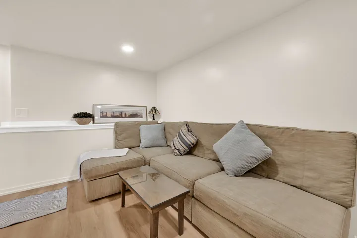 Recessed ceiling lighting, light-toned wall paint, wood-finish flooring, and a low wall partition