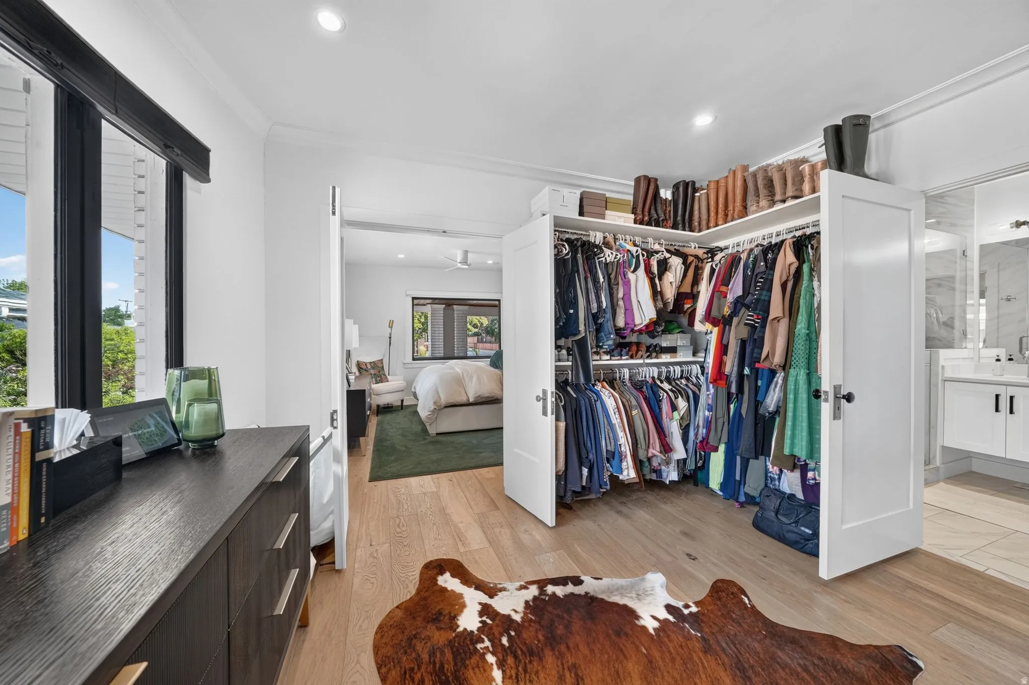 Expansive custom walk-in closet and primary bathroom.  Natural light pouring in, dual-direction custom window coverings, AND hook ups in closet for stackable washer & dryer.