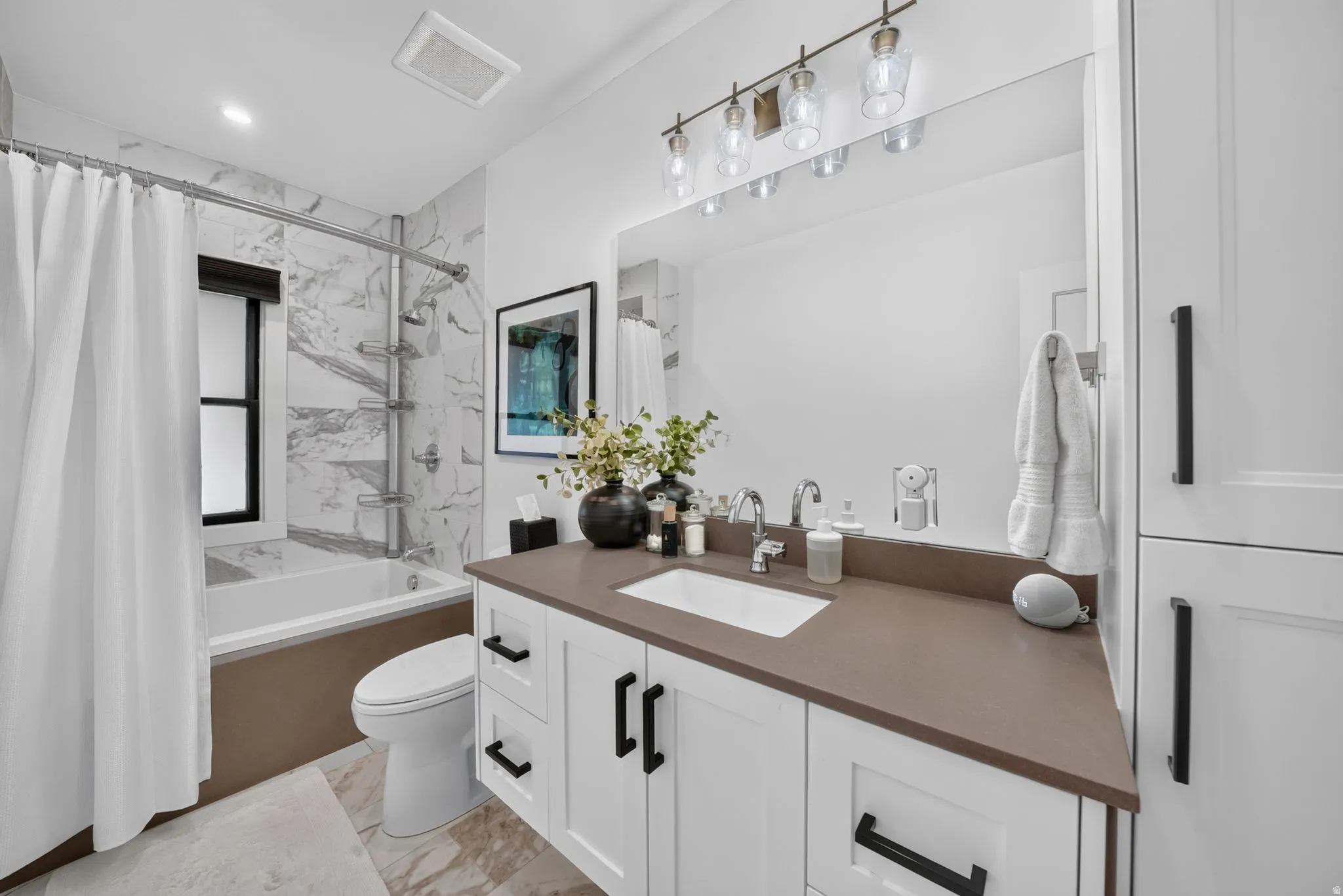 2nd bathroom on main floor.  Large, deep tub/shower with tile walls and shelves.  Quartz countertops, custom linen closet.