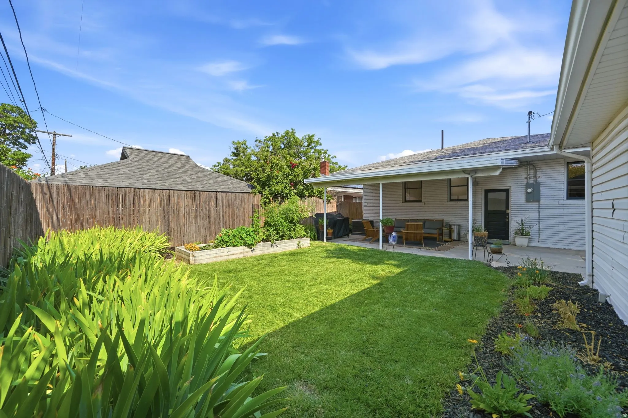 Well maintain back yard, full sprinkler & drip system, raised garden boxes, manicured flower beds, bamboo privacy fence, and covered patio.
