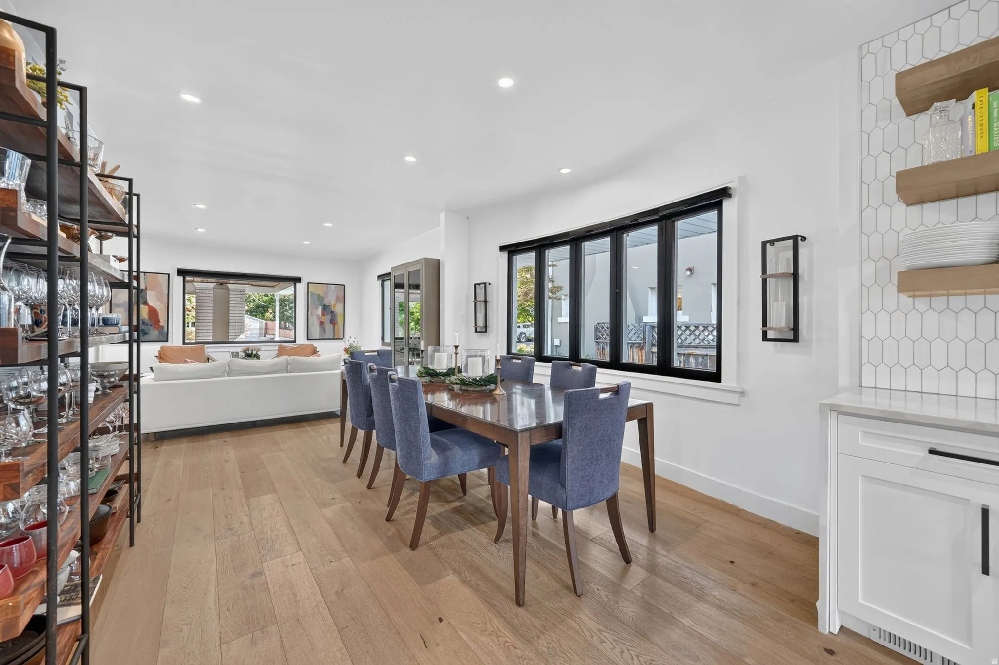 Dining room that openly flows from living room into kitchen. Beautiful large black frame windows that fill the space with natural light.