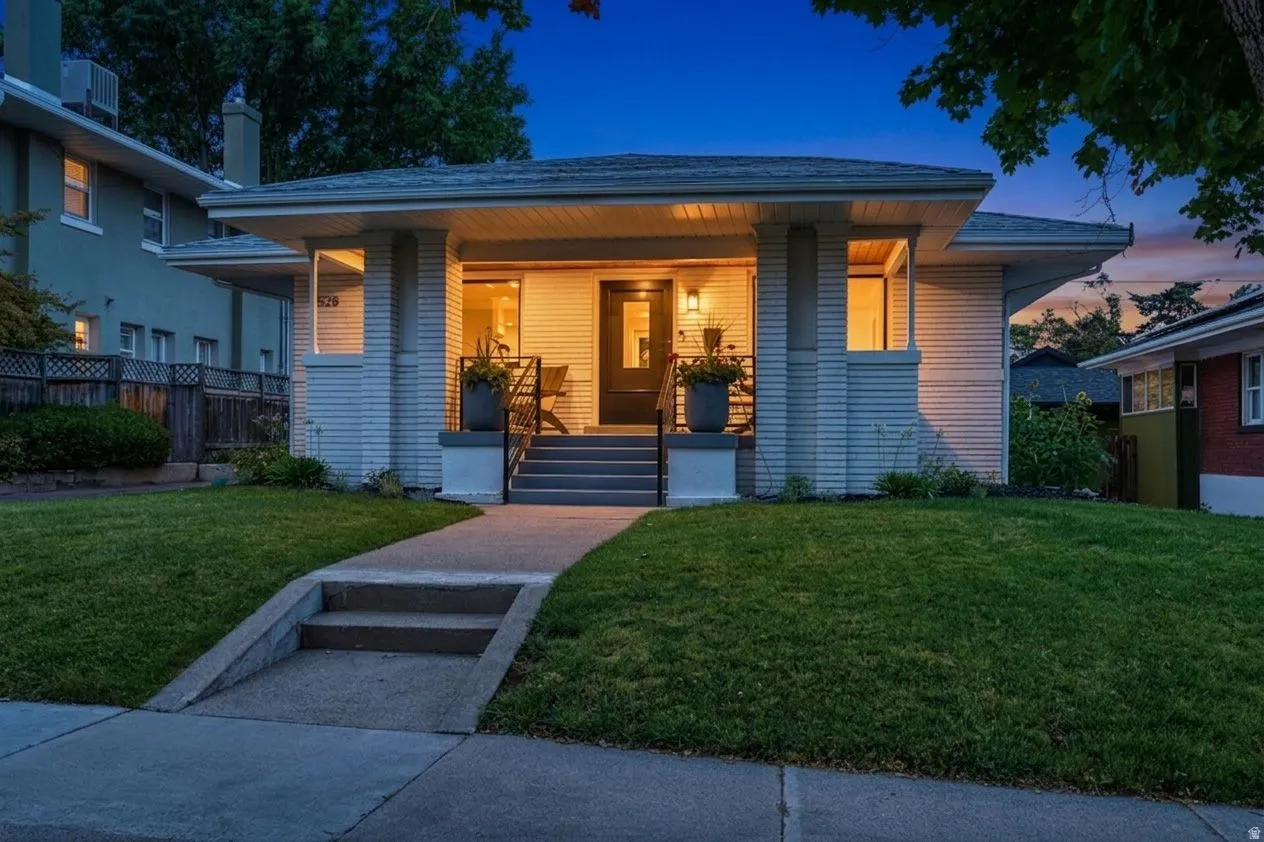 Craftsman bungalow, white brick exterior, covered front porch, & beautiful front yard.