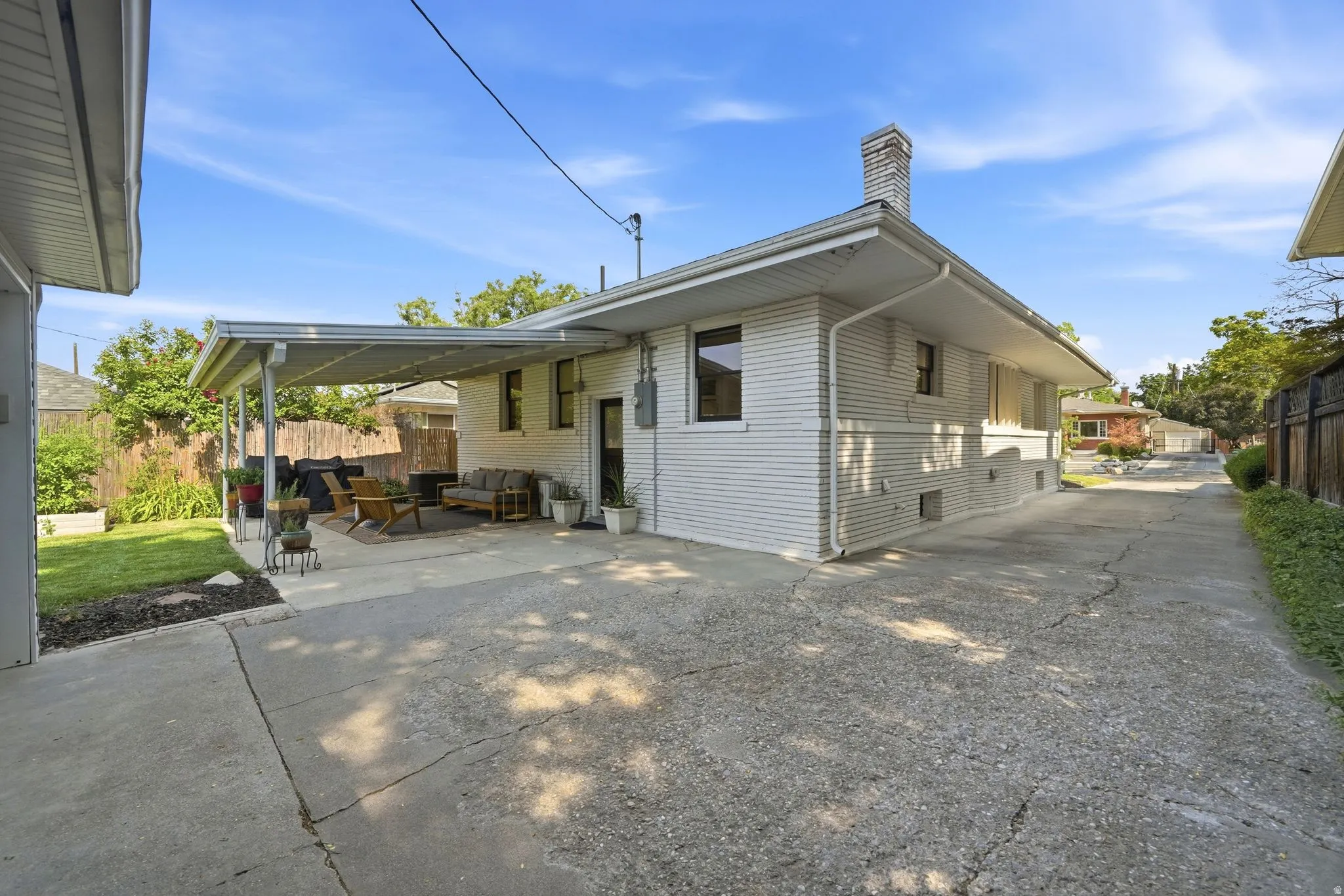 Expansive concrete driveway alongside home leading to detached 2 car garage. EV car charger on back of house with easy access to driveway.