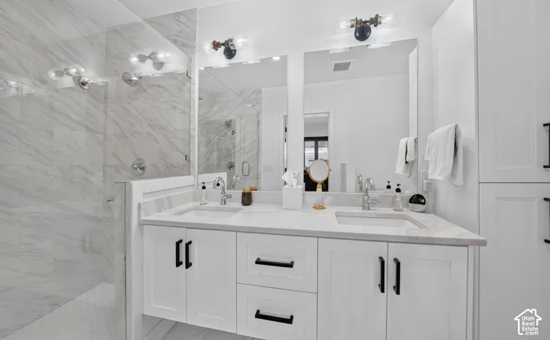Primary bathroom retreat.  Dual vanity, quartz countertops, spa walk-in shower with euro glass enclosure, and custom linen cabinet.