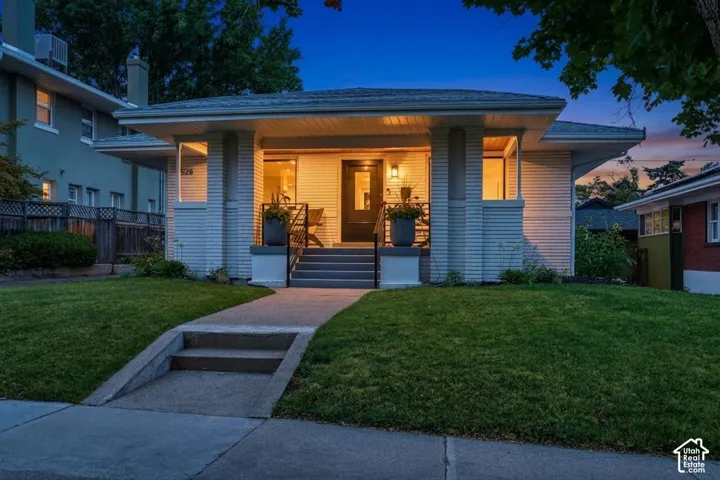 Craftsman bungalow, white brick exterior, covered front porch, & beautiful front yard.