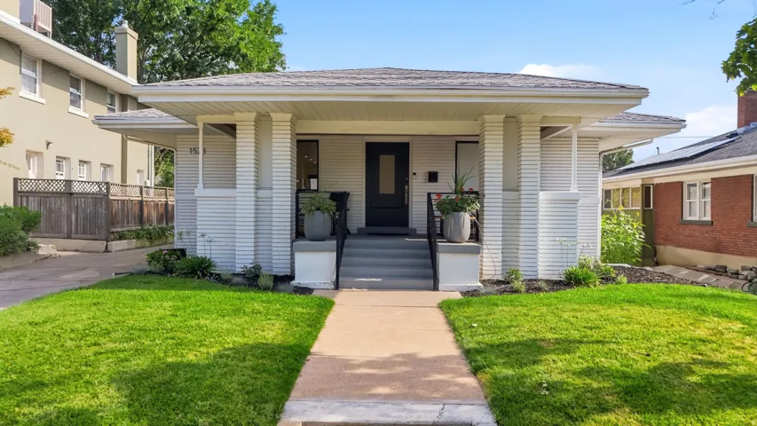 Classic craftsman bungalow.  White brick exterior, covered front porch, & perfectly manicured front yard.