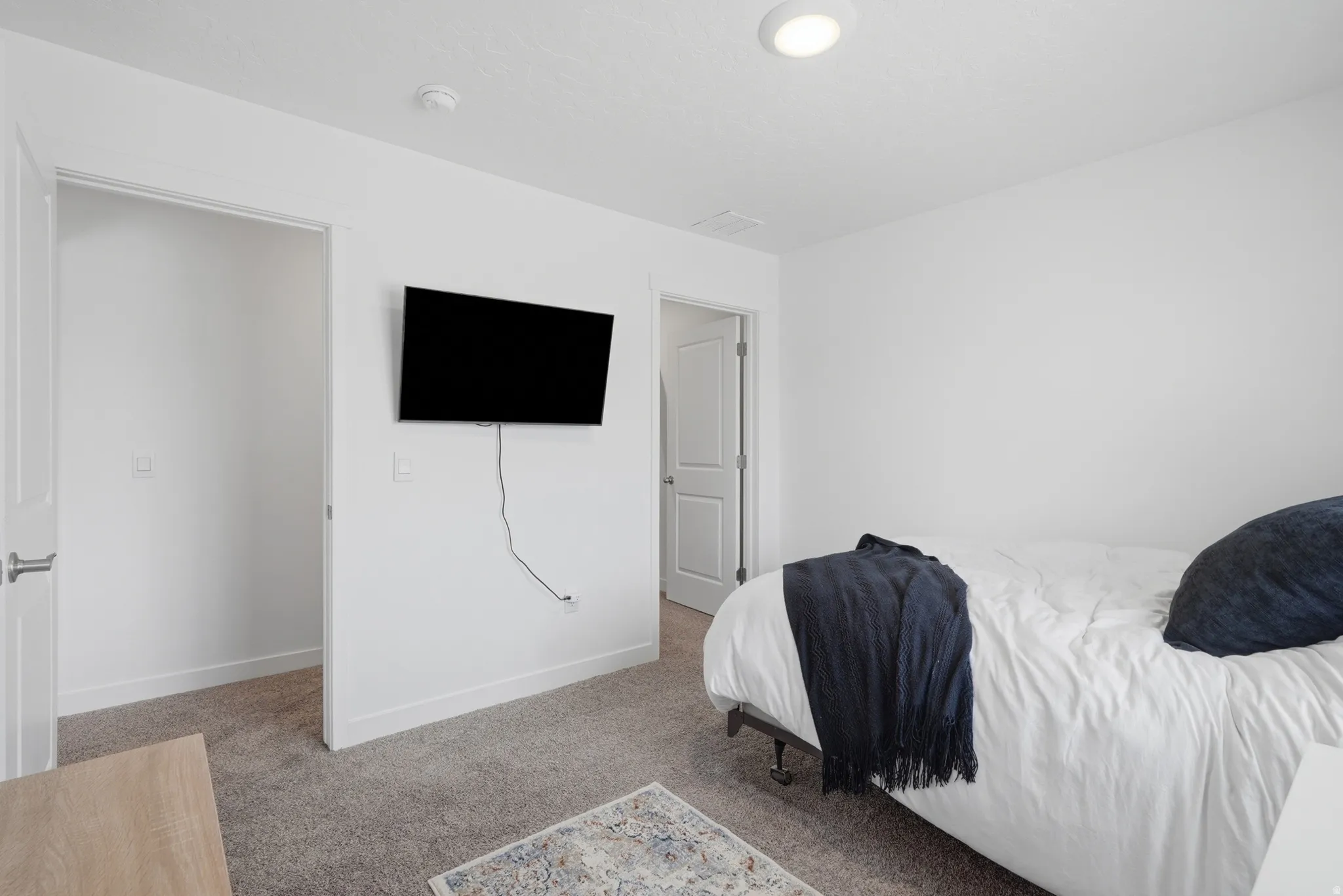 White interior walls, recessed lighting, and carpeted flooring