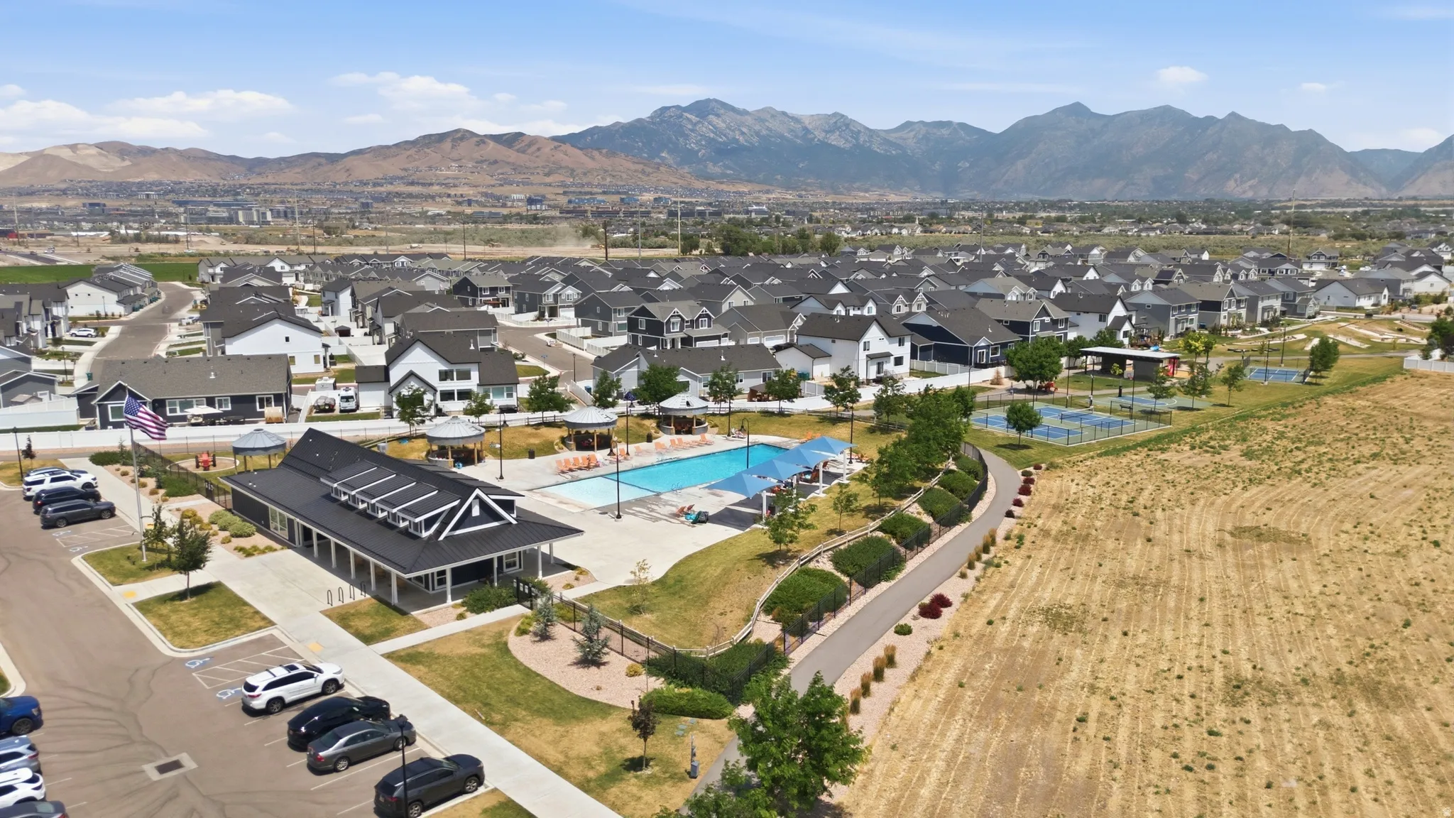 Community clubhouse featuring a swimming pool, multiple sports courts, and mountain scenery