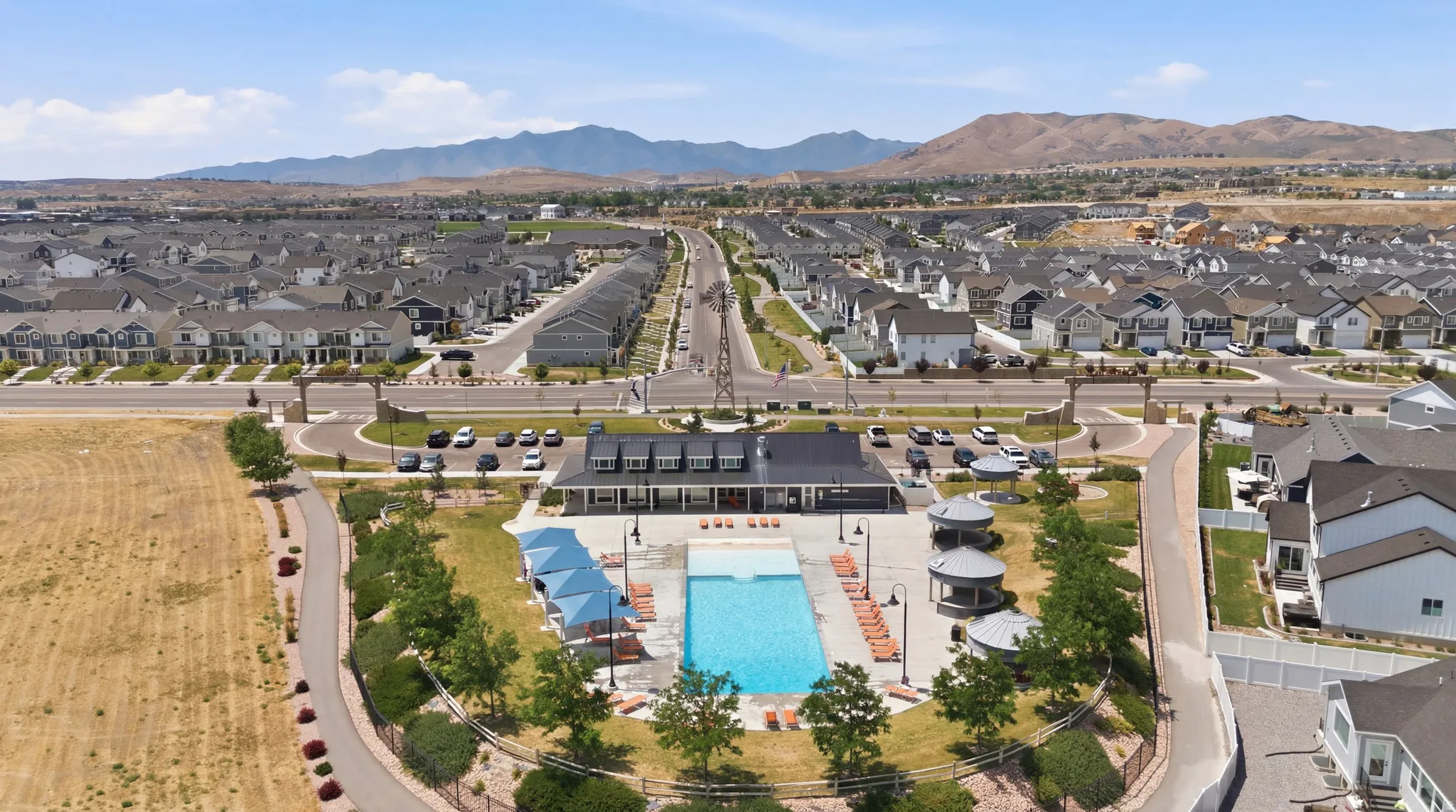 Community club house featuring an outdoor pool, multiple gazebos, and a patio area with lounge chairs