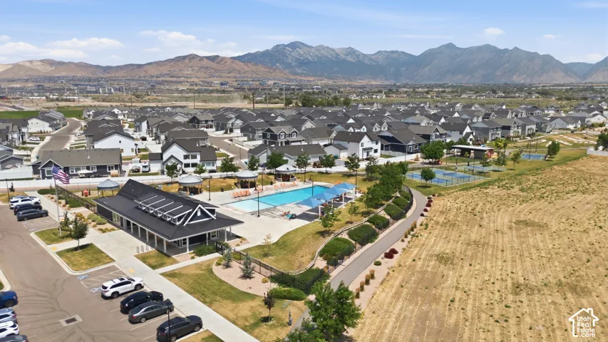 Community clubhouse featuring a swimming pool, multiple sports courts, and mountain scenery